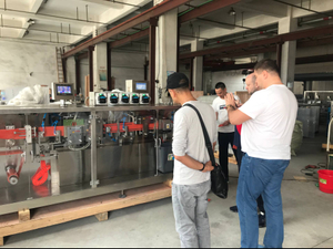 Pelanggan Rusia melawat dan memeriksa ampoule plastik minyak zaitun yang membentuk mengisi mesin pengedap di kilang